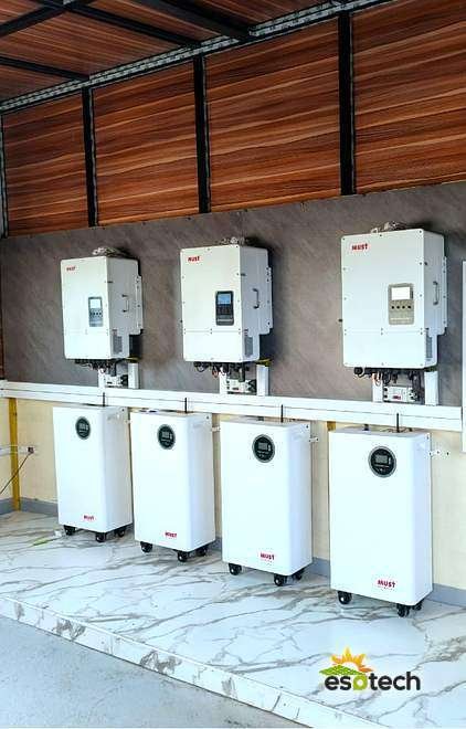 Trois onduleurs MUST 12 kW montés en triphasé et quatre batteries lithium MUST en local technique, installation solaire de 42,6 kWc à Kaolack, réalisée par Esotech