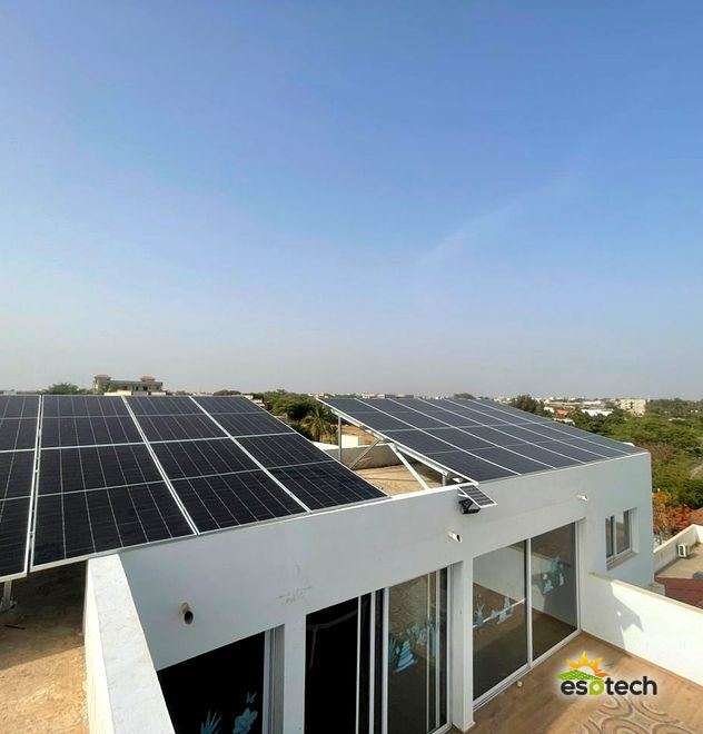 Champ de panneaux solaires en toiture-terrasse d'une villa, installation triphasée de 14,4 kWc à Ngaparou, réalisée par Esotech